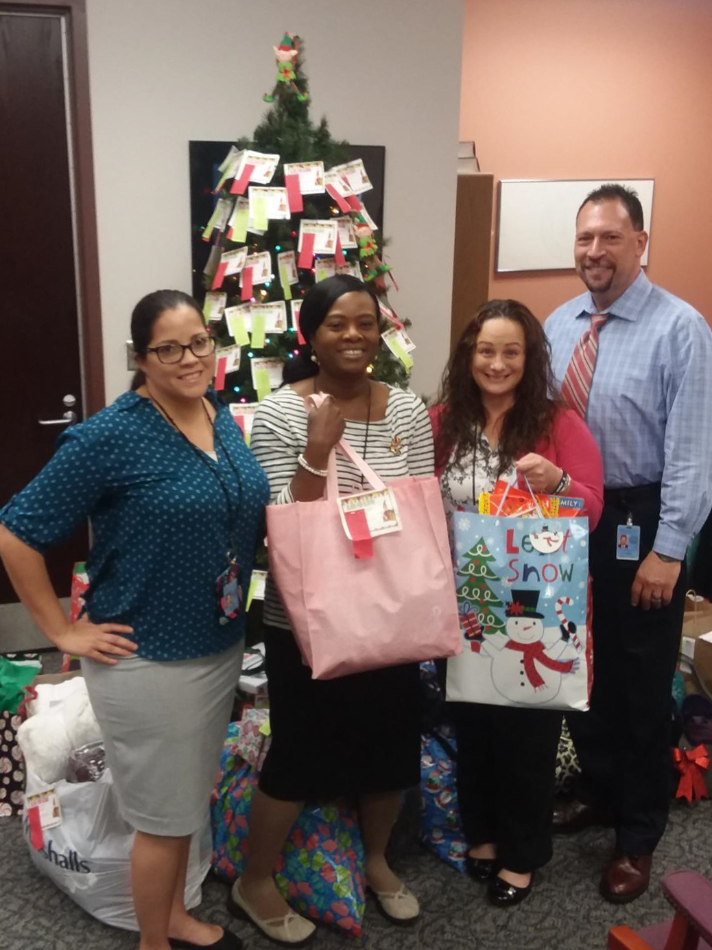 JDP Staff with presents in front of Christmas tree